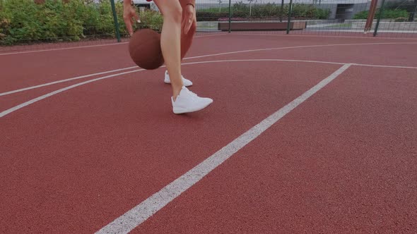 Female Basketball Player Dribbling on City Playground. Ball Is Jumps, Bounce. White Sneakers