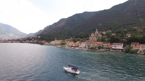 Motor Yacht Sails Along the Bay of Kotor Past the Prcanj Coast