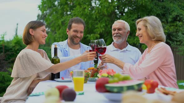 Old and Middle-Aged Couples Toasting and Clinking Wine Glasses, Happy Marriage