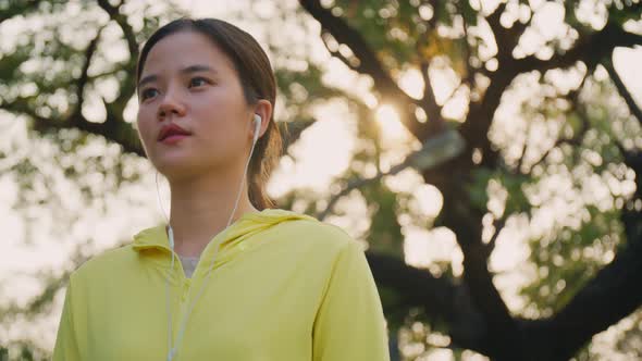 Beautiful young Asian woman walking cardio workout in the park.