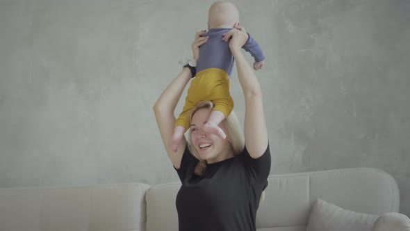 Woman playing with toddler son at home