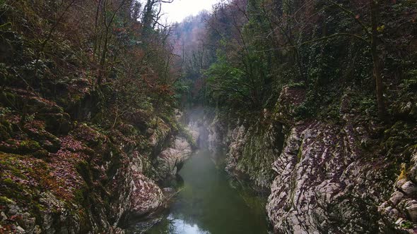 Flying Over a River Through a Narrow Canyon with White Rocks Sochi