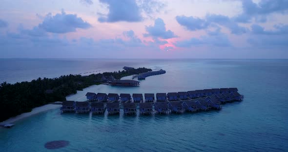 Tropical fly over island view of a white sand paradise beach and blue sea background in high resolution