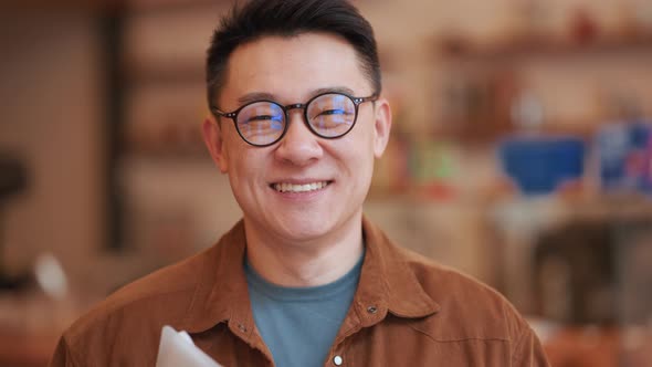Smiling Asian young man wearing eyeglasses looking at the camera