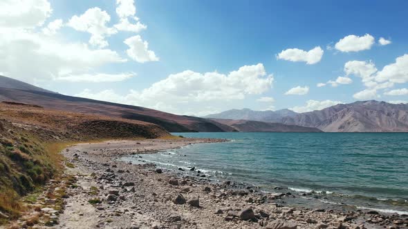 Aerial Over Bulunkul Lake Shore in Sunny day.Pamir Highway Silk Road Travel Adventure in Tajikistan