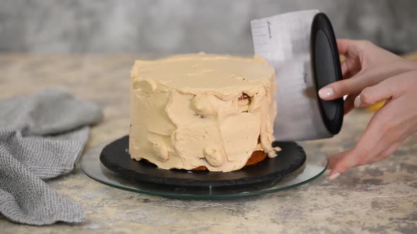 Aligning the caramel cream with a pastry pallet on a biscuit cake. Baking a caramel biscuit cake