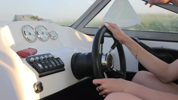 Female Hands Holding the Rudder of a High Speed Motor Boat Close Up