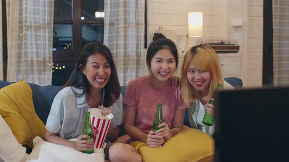 Female drinking beer watching TV cheer soccer funny moment together on sofa in living room.