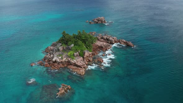 Aerial arc shot around small oasis desert island St. Pierre, Praslin