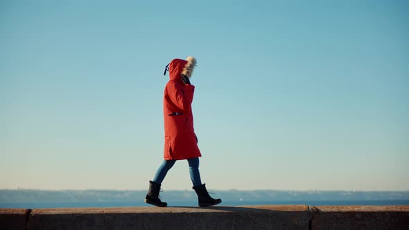 Woman In Parka Walking In Sea Beach. Holiday Vacation Tourist Journey Trip In Cold Day.