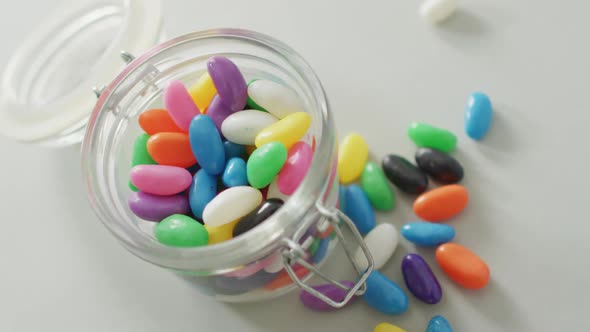 Video of multicoloured jelly sweets in glass jar on white background