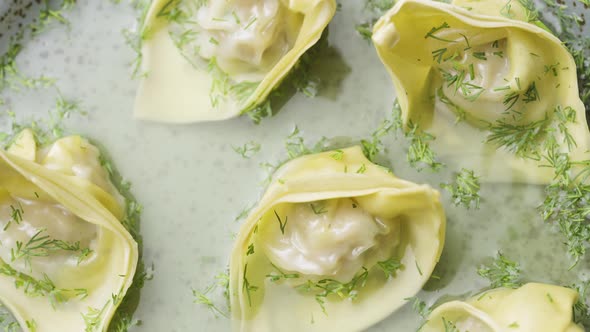 Top View of Soup with Wontons Spinning on a Gray Plate Close Up