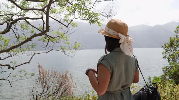 Beautiful young asian woman with straw hat enjoying the view on Brissago.