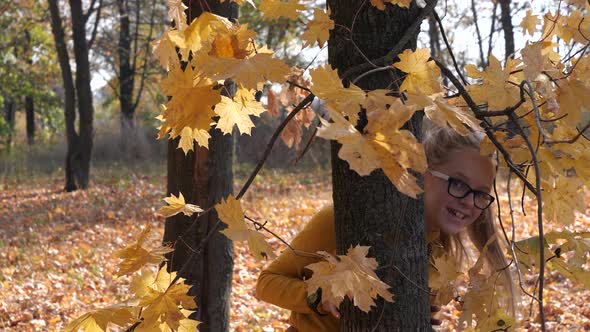 Pretty Blonde Teen Girl Hiding Behind Maple Tree