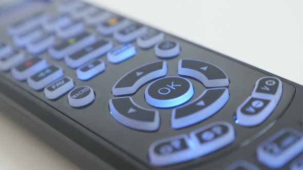 Close-up pressing OK button on multimedia device remote control 4K video