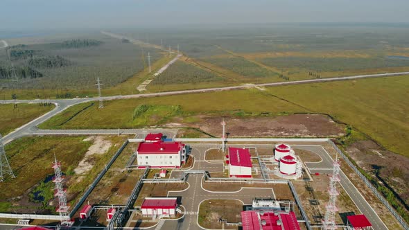 A Drone Flies Over a Natural Gas Processing Plant Around a Swamp and Taiga