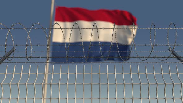 Waving Flag of Netherlands Behind Barbed Wire