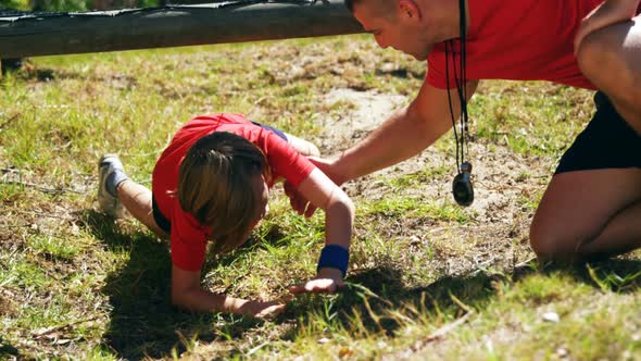 Kids crawling under the net during obstacle course training