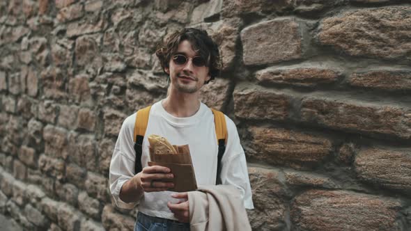 Portrait of Young Man with Taco against Brick Wall
