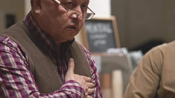 Depressed Senior Man Talking at Support Group Meeting