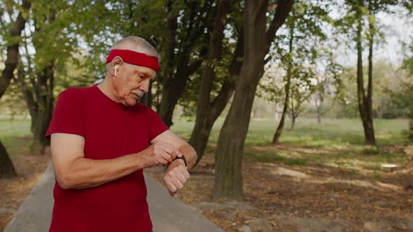 Senior Sport Man Starting Smart Watch Timer, Tracking Distance and Start Running in Public Park