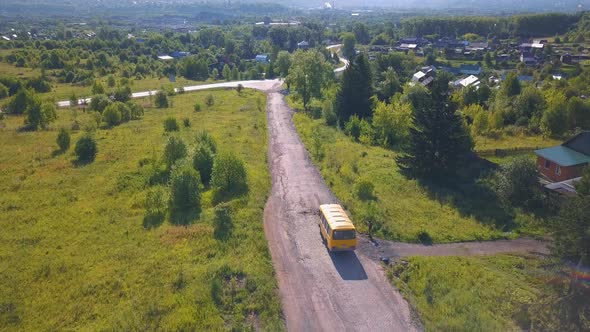 A long road on which a yellow bus rides