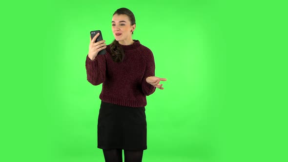 Smiling Girl Talking for Video Chat Using Mobile Phone and Rejoice on Green Screen