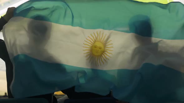 Family With Child Waving Argentinian Flag, Watching Football Game at Stadium