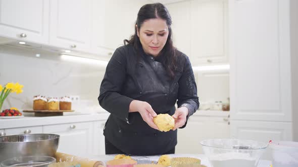 a Woman Cook Lays Out Dough in Paper Molds for Baking Easter Cakes