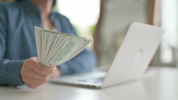 Close Up of Man Giving Dollars While Working on Laptop