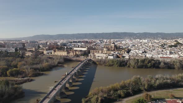 Drone flight over Roman bridge towards Mosque-Cathedral of Cordoba