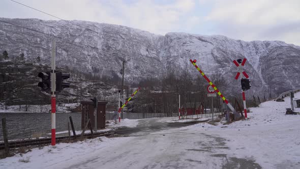 Booms closing down and lights starts flashing to warn about incoming train at level crossing - Warni