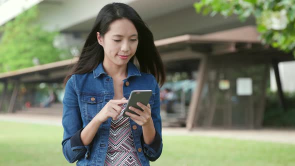 Woman looking at cellphone at outdoor park