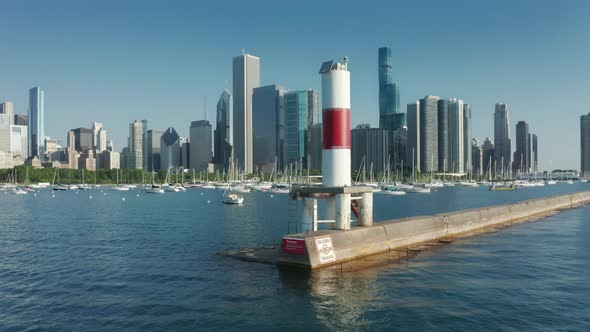 Drone Flying Around White and Red Signal Tower at the Chicago Marina Entrance