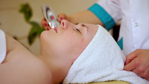 A Relaxed Girl with Her Eyes Closed Lies on the Couch in the Spa Salon, While the Cosmetologist