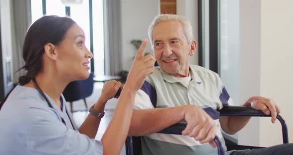 Animation of happy biracial female doctor taking care of caucasian senior man