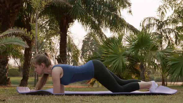 Sportswoman in Sportswear Hard Working to Press in Tropical City Park