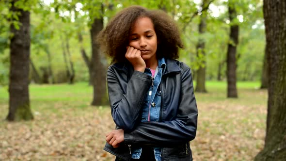 Young Beautiful Sullen African Girl Is Bored in the Park