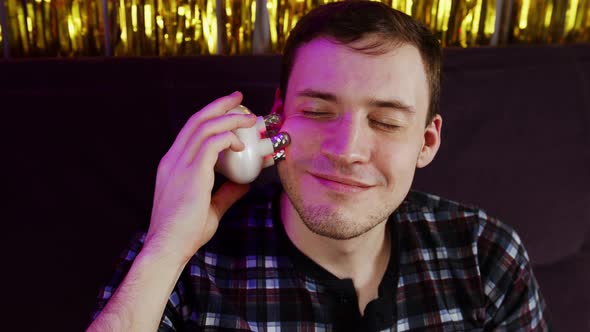 Young Happy Man Using 3d Massager for Face