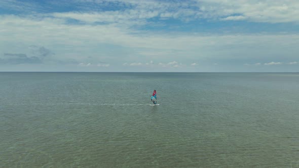 Drone Flight Over Calm Sea Surface with Glissing Windsurfer