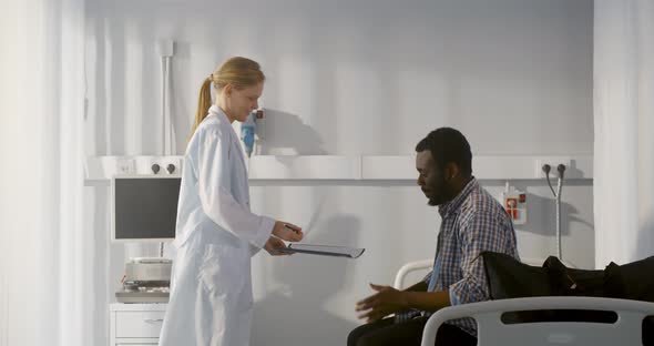 African Man Patient Signing Form and Being Discharged From Hospital