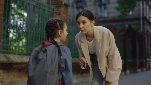 Female Teacher Standing with Schoolgirl Giving Recommendations and Pointing Finger on Child