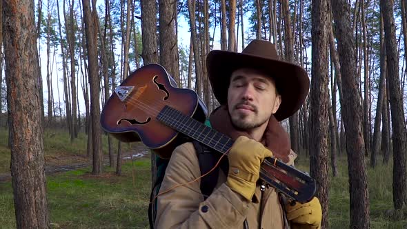 A Man with a Guitar in the Forest