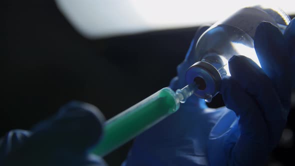 Hands in Gloves with Syringe and Medicine