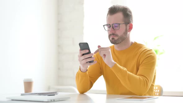 Attractive Man Using Smartphone in Office