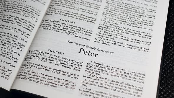 Close Up Shot of  Bible Page Turning to the book of Second Peter