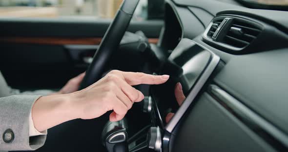 Close Up of Female Hand Driver Entering an Address Into the Navigation System in Modern Car.