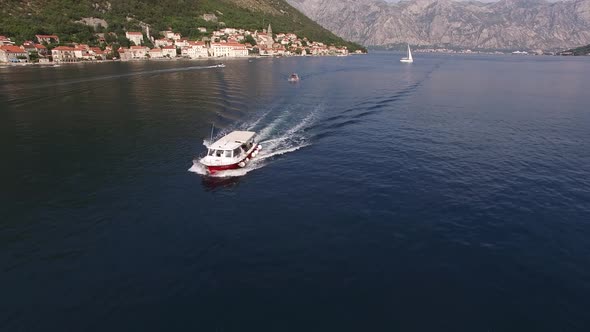 Tourist Boat Sails Along the Bay of Kotor with the Mountains in the Background