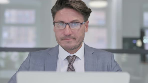 Close Up of Middle Aged Businessman with Laptop Shaking Head as No