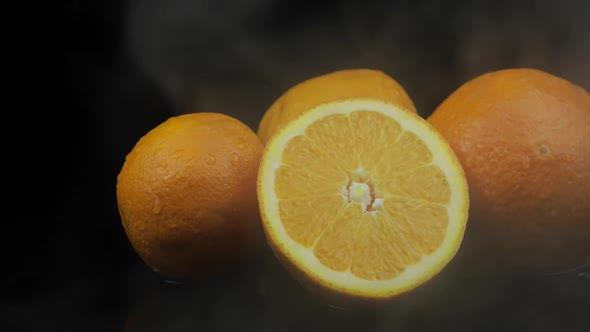 Tropical Fruit Orange in Cold Ice Clouds of Fog Smoke on Black Background